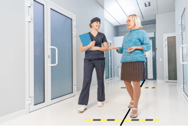 Technician and woman preparing for a six-minute walk test in the medical office hallway.